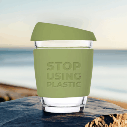 Reusable coffee cup on a coastal rock – eco-friendly coffee habits